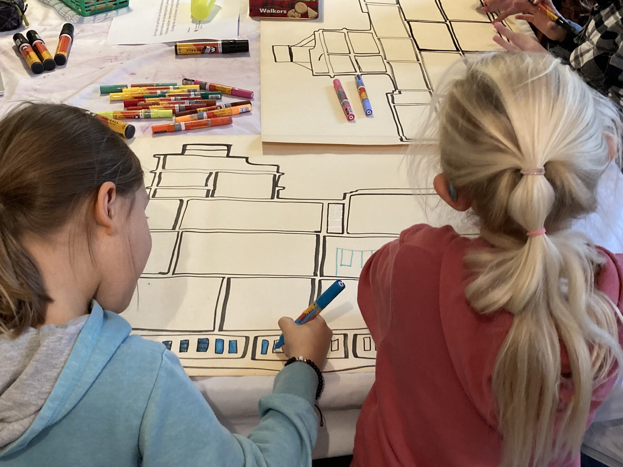 Zwei Kinder malen auf bunten Flipcharts.