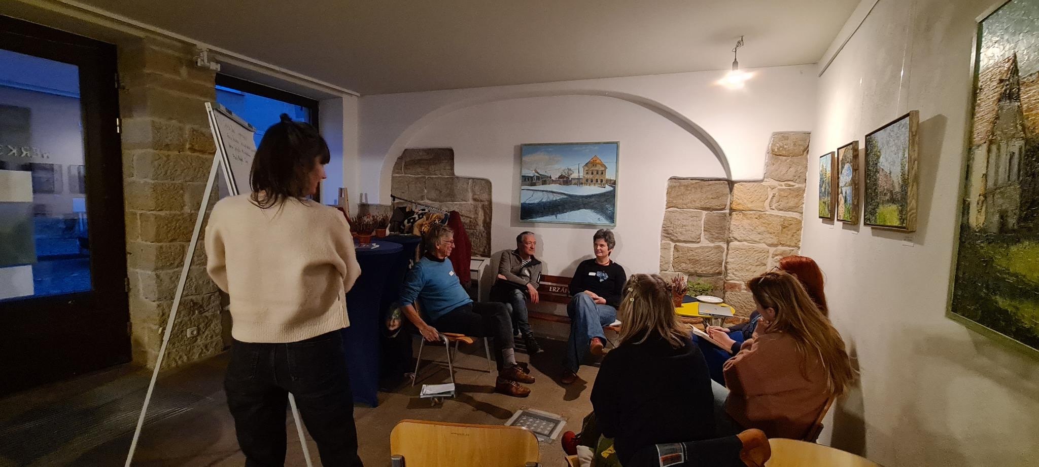 eine kleine Gruppe Menschen sitzt zusammen und sprechen über ein Thema