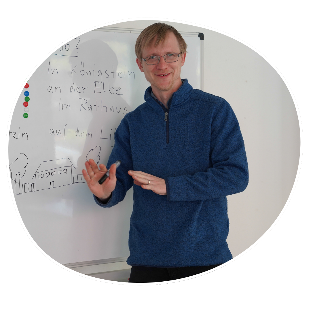 Thomas vor einer Tafel mit Schrift