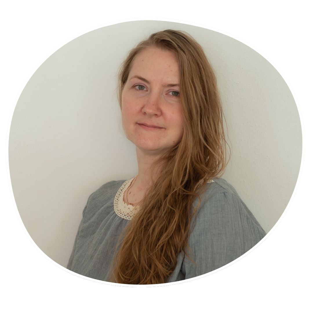 Ein BIld von Natalia Kovalskaia. Sie hat langes glattes rotblondes Haar. auf dem Bild trägt sie ein graues Oberteil.